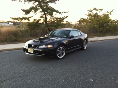 2002 Ford Mustang - Black 2002 Ford Mustang coupe seen from the front-three-quarter angle on a road.