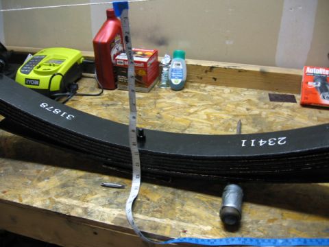 1995 Ford Bronco - Leaf springs are shown with part numbers and a measuring tape, indicating a measurement or inventory process.