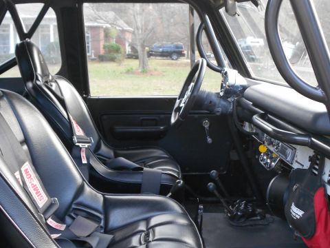 1967 Ford Mustang - Interior view of a modified vehicle with racing seats and a roll cage, showing the dashboard and gear shifters.
