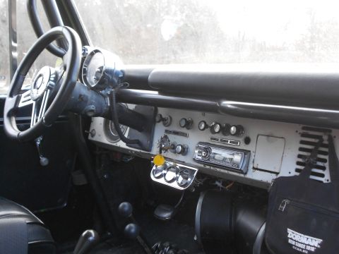 1967 Ford Mustang - The interior of a classic vehicle shows a dashboard with an aftermarket radio and auxiliary gauges.