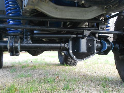 1967 Ford Mustang - Underbody view of a solid front axle with a black differential cover, showing coil springs (blue), leaf springs, a steering stabilizer, tie…