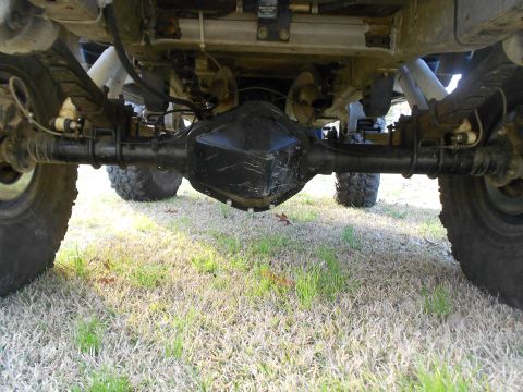 1967 Ford Mustang - Underside view of a vehicle's rear solid axle, showing the black differential housing (pumpkin), leaf springs, shock absorbers, and off-roa…