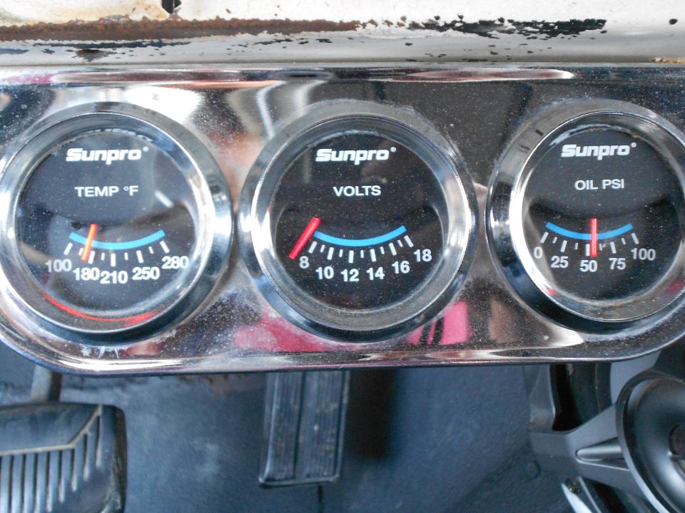 Three Sunpro gauges (temp, volts, oil pressure) in chrome panel on a 1967 Mustang dash