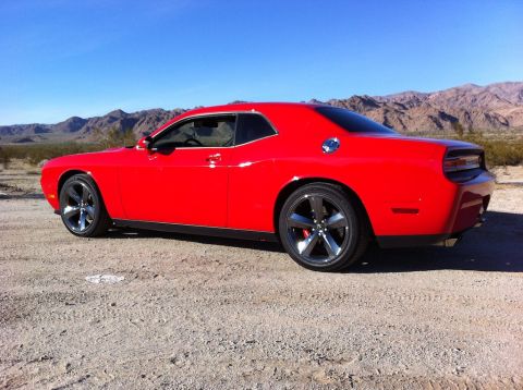 2010 Dodge Challenger - A red Dodge Challenger is seen from the rear quarter angle in a desert landscape.