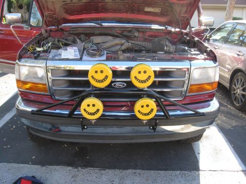 1995 Ford F-150 - Front view of a 1995 Ford F-150 with the hood up, yellow smiley face lights on a bull bar.
