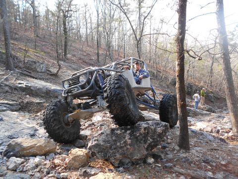 1967 Ford Mustang - A custom-built buggy tackles a challenging rocky trail in a forest setting.