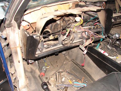 1973 Ford Ranchero - The interior of a vehicle shows a disassembled dashboard with tools scattered on the floor.