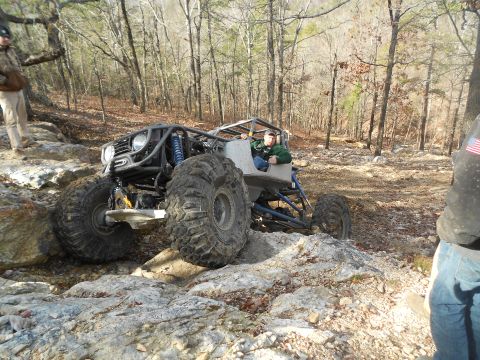 1967 Ford Mustang - A custom-built off-road buggy tackles a challenging rocky trail in a wooded area.