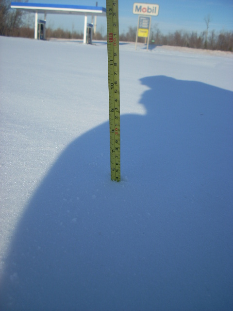 2000 Chevrolet Tahoe - Snow depth is measured in front of a gas station, indicating significant snowfall.