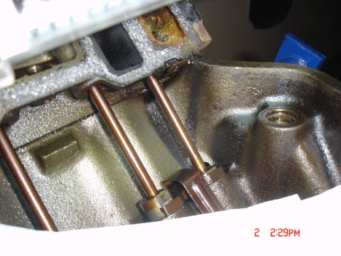 1995 Ford Bronco - Close-up of engine components, including pushrods and rocker arms, showing signs of lubrication.