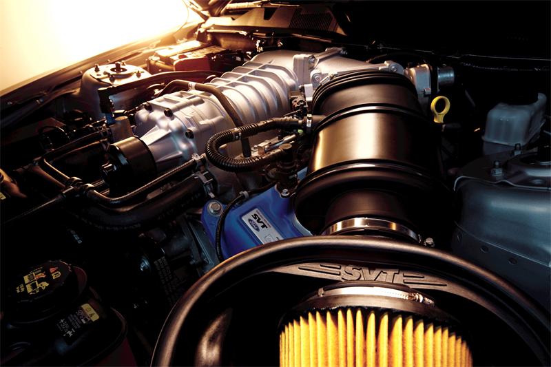 Close-up of a 2012 Ford Mustang Boss 302 engine with a supercharger and SVT branding