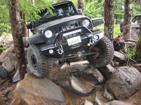 2008 Jeep Wrangler - A Jeep Wrangler navigates a rocky trail, with another vehicle visible in the background.