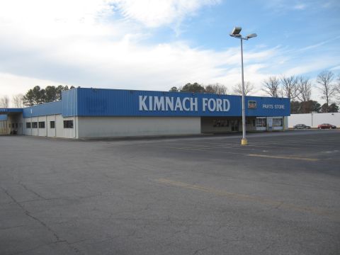 1968 Shelby GT500 - Exterior view of the Kimnach Ford dealership, a prominent blue facade with white lettering and a 'Parts Store' section.