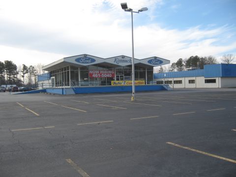 1968 Shelby GT500 - A Kimnach Ford dealership is shown with a parking lot and a sign indicating they are hiring.