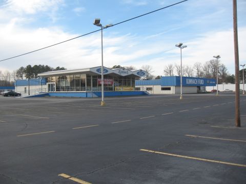 1968 Shelby GT500 - Exterior view of Kimnach Ford dealership on a cloudy day, showing the building and surrounding empty parking lot.