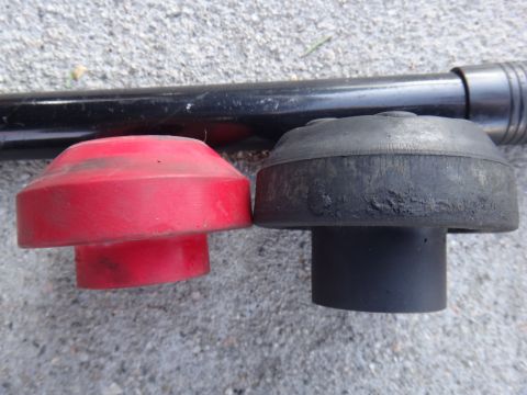 2000 Lincoln Continental - Comparison of a red and a black suspension component, possibly for aftermarket upgrade.