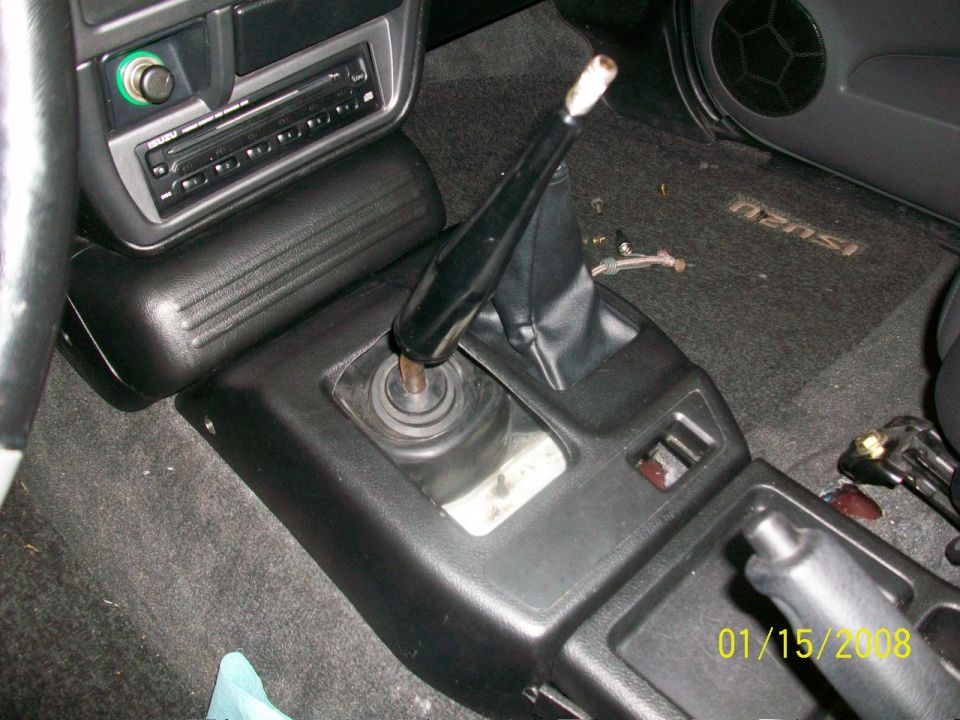 Interior view of a vehicle's center console showing a manual transmission shifter and part of a car stereo