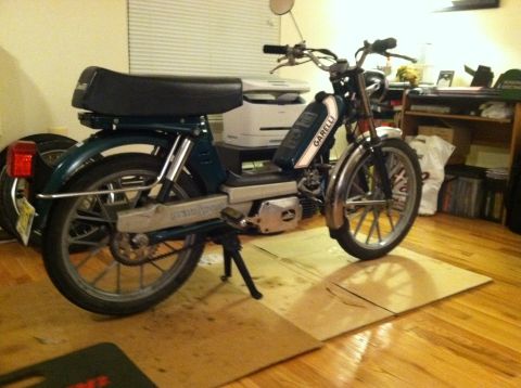 1981 Garelli Rally Sport - A green moped with chrome fenders is parked indoors on a wooden floor.