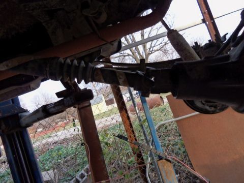 1989 Ford Bronco - Close-up view of a vehicle's rear axle assembly, including the shock absorber and exhaust pipe.