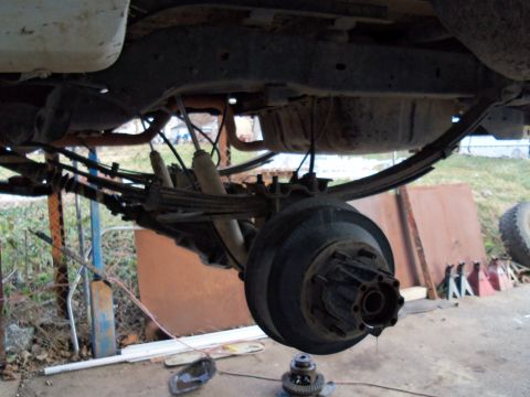1989 Ford Bronco - Close-up view of a vehicle's rear axle assembly, showing suspension components and brake drum.