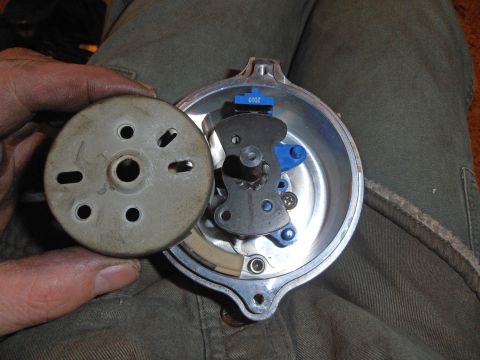 1990 Ford Bronco - Hand holding a distributor rotor beside the open distributor body and ignition pickup, dated 2010.
