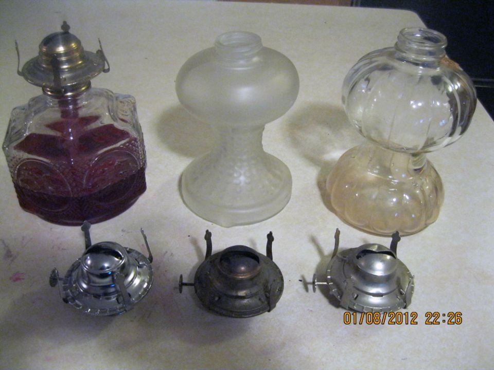 Three glass oil lamp bases and three metal burner assemblies