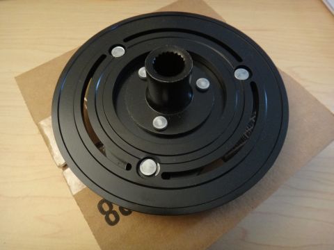 2003 Ford Taurus - A black AC clutch hub, a component of a vehicle's air conditioning system, is shown against a cardboard background.