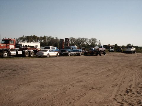 1996 Ford Bronco - A collection of vehicles, including trucks and cars, are parked in an outdoor lot.