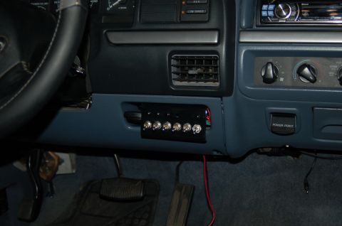 1992 Ford F-150 - Interior shot of a truck's dashboard, focusing on a custom-installed switch panel and power outlet.
