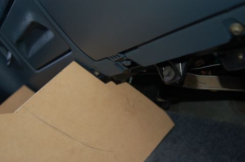 1992 Ford F-150 - A cardboard template is positioned on the floor under the dashboard of a vehicle.