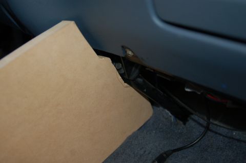 1992 Ford F-150 - A close-up view of the interior of a vehicle, showing a cardboard panel and wiring.