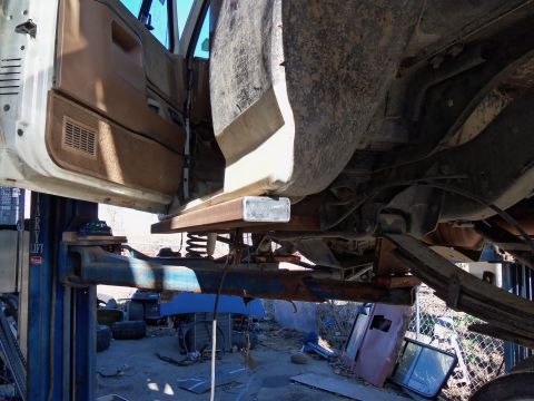 1989 Ford Bronco - Underside view of a 1989 Ford Bronco on a lift, highlighting the frame and suspension components.