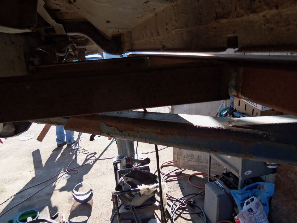 Underbody frame and suspension components with tools and equipment on the ground