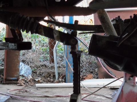 1989 Ford Bronco - Undercarriage view of a vehicle's rear axle and suspension components, possibly during maintenance.