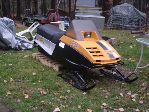 1979 Ford Bronco - A yellow and black snowmobile sits on a wooden pallet in a grassy yard.