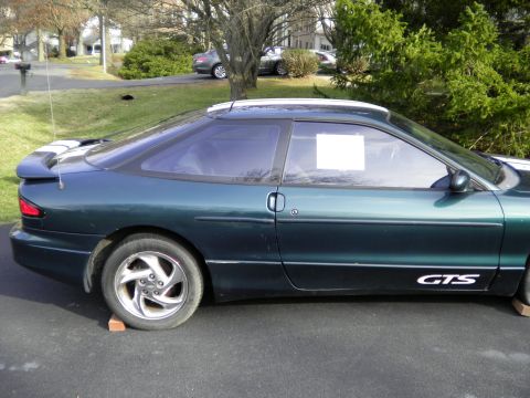 1997 Ford Probe - Side profile of a dark green 1997 Ford Probe GTS, a rear spoiler and distinctive side decals.