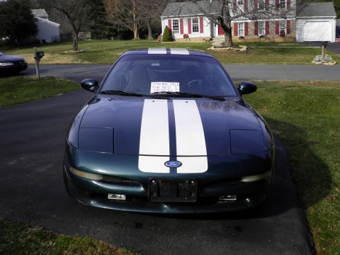 1997 Ford Probe - This Ford Probe has racing stripes and a sign on the windshield that says 'EXPECTEDLY THE RED DEMON'.