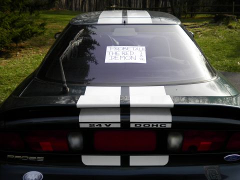 1997 Ford Probe - A note on the rear window reads 'PROBE TALK THE RED DEMON 1 8 12'.
