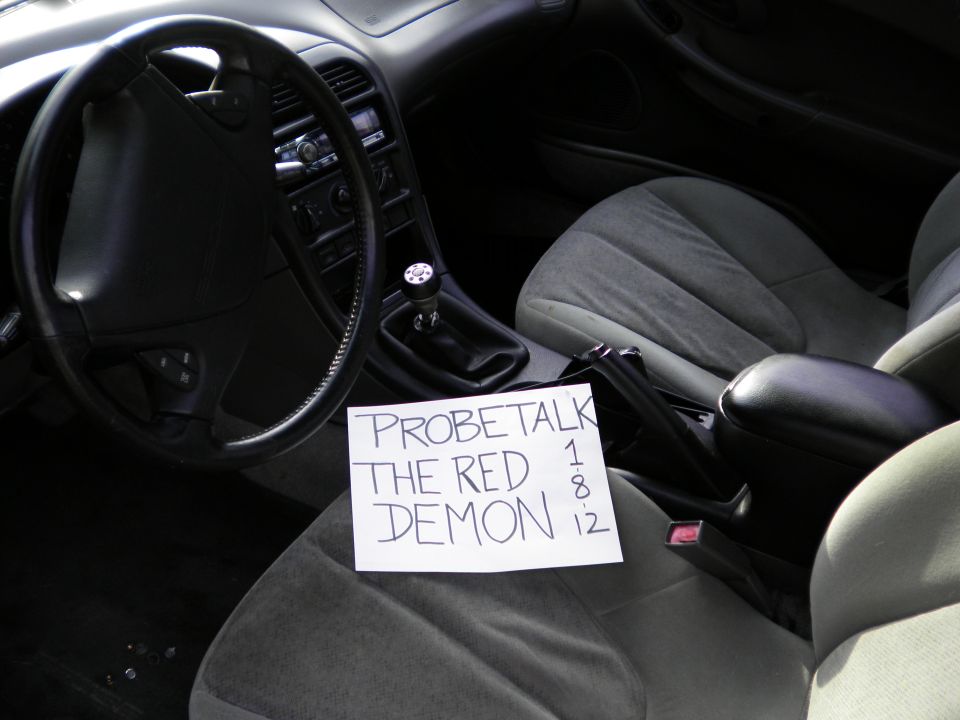 Interior view of a car with a handwritten note that says "PROBETALK THE RED DEMON 1 8 12"