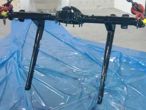 1963 Ford Galaxie - Rear axle assembly being worked on, suspended by chains over blue plastic sheeting.