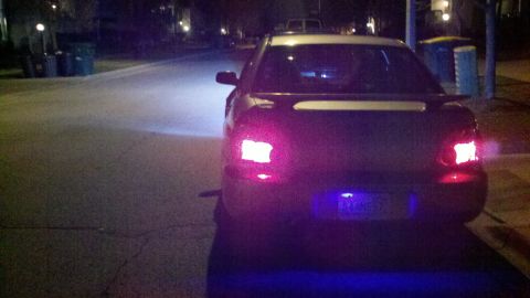 1999 Mercury Grand Marquis - Rear view of a sedan with custom lighting modifications parked on a street at night.