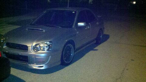 1999 Mercury Grand Marquis - Silver Subaru Impreza WRX parked on asphalt at night.