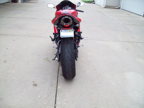 1999 Mercury Grand Marquis - The back of a red motorcycle is shown, with a wide tire and prominent exhaust pipe.