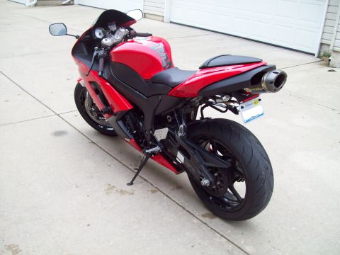 1999 Mercury Grand Marquis - A red sport motorcycle is parked on a concrete driveway in front of a garage door.