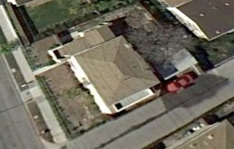 1968 Ford Mustang - A red car is parked in the driveway of a suburban house.