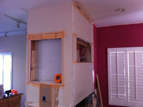 1989 Yugo Cabrio - Wall framing and drywall installation in progress, with a window opening and a roll of tape visible.