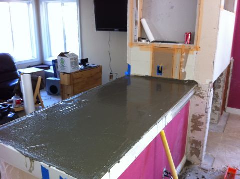 1989 Yugo Cabrio - Pouring wet concrete into a countertop form during a home improvement project.