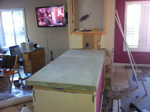 1989 Yugo Cabrio - A room undergoing renovations, a partially built countertop and a television mounted on the wall.