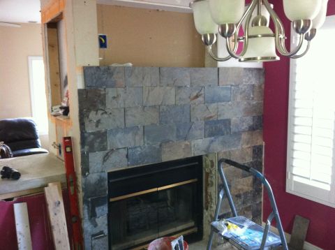 1989 Yugo Cabrio - A fireplace is being renovated with new slate tile facing and surrounding construction materials visible.