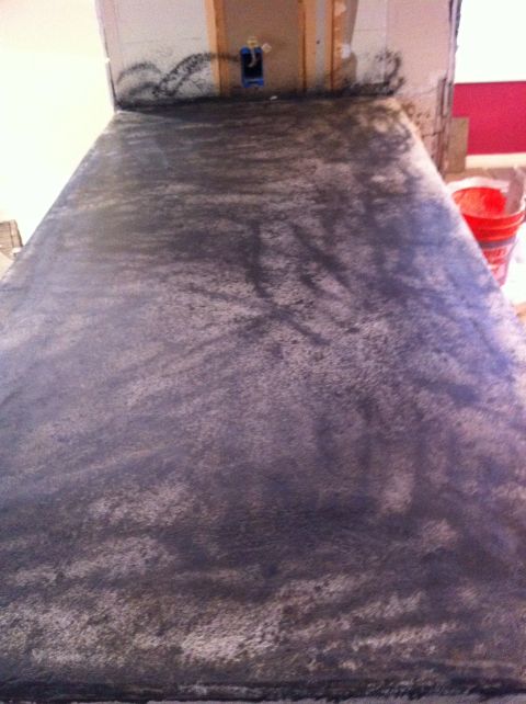 1989 Yugo Cabrio - Countertop surface with dark speckled finish, unfinished wall behind it with electrical box.